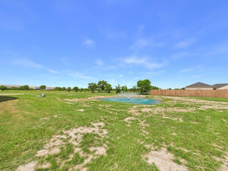 Private pond surrounded by expansive acreage and open green space.