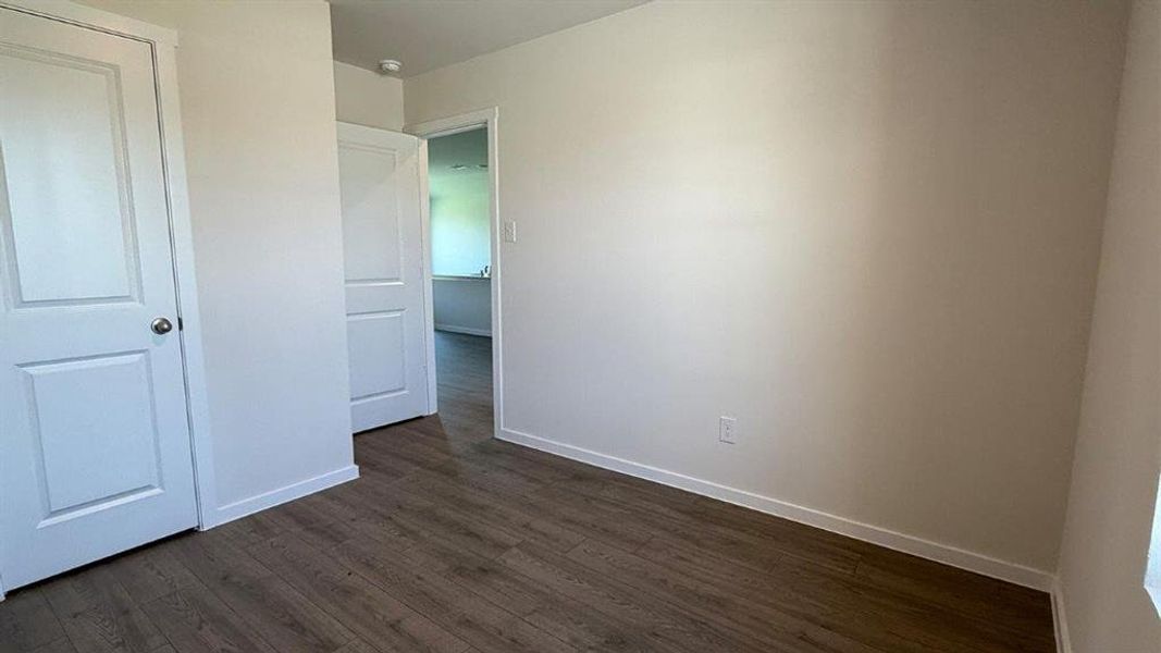 Interior space featuring wood-finish flooring, white baseboards, and light-toned walls Interior space featuring wood-finish flooring, white baseboards, and light-toned walls