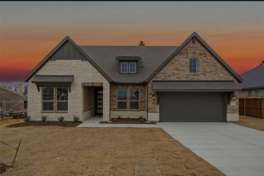 View of front of house featuring concrete driveway, roof with shingles, stone siding, brick siding, and a garage View of front of house featuring concrete driveway, roof with shingles, stone siding, brick siding, and a garage