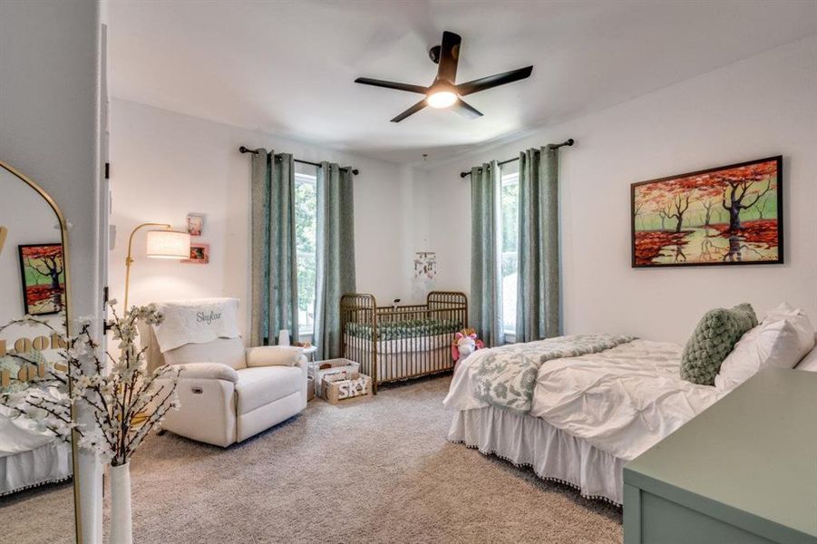 Bedroom with light carpet and a ceiling fan