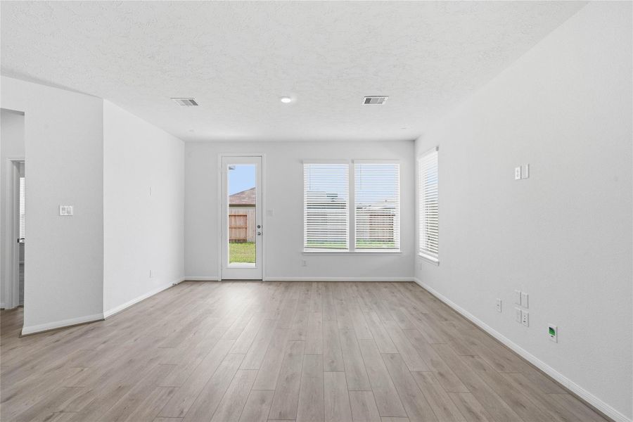 Bring family and friends together in this beautiful Great Room! It features soaring ceilings, recessed lighting, custom paint, vinyl plank flooring, large windows that fill the space with natural light, and a back access door that directly goes out to the patio and backyard green space! Bring family and friends together in this beautiful Great Room! It features soaring ceilings, recessed lighting, custom paint, vinyl plank flooring, large windows that fill the space with natural light, and a back access door that directly goes out to the patio and backyard green space!