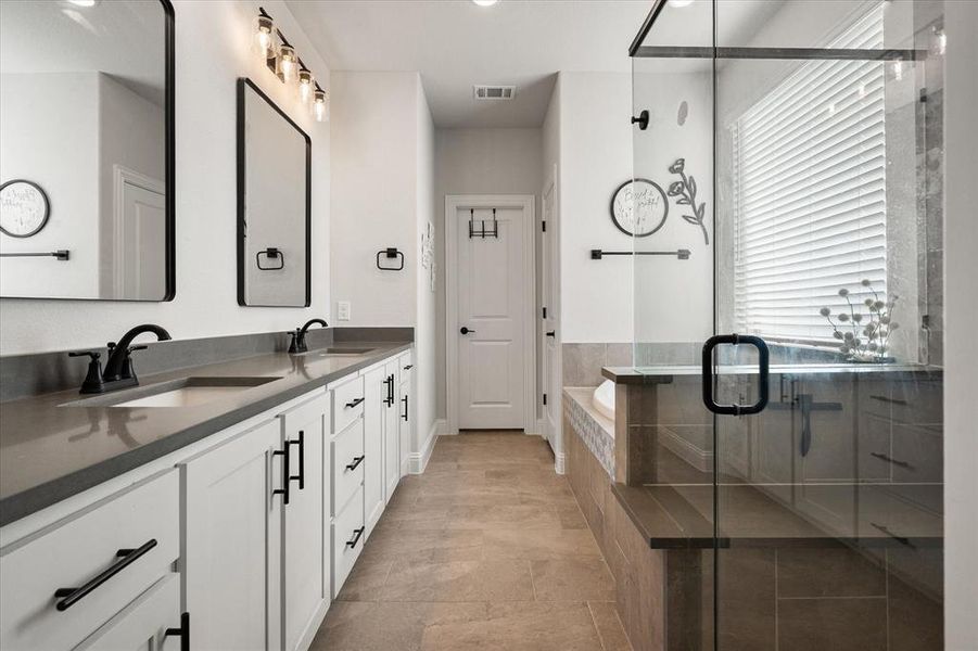 Full bath with double vanity, a bath, a stall shower, and recessed lighting