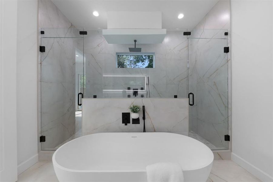 Full bathroom featuring a soaking tub, a marble finish shower, and recessed lighting