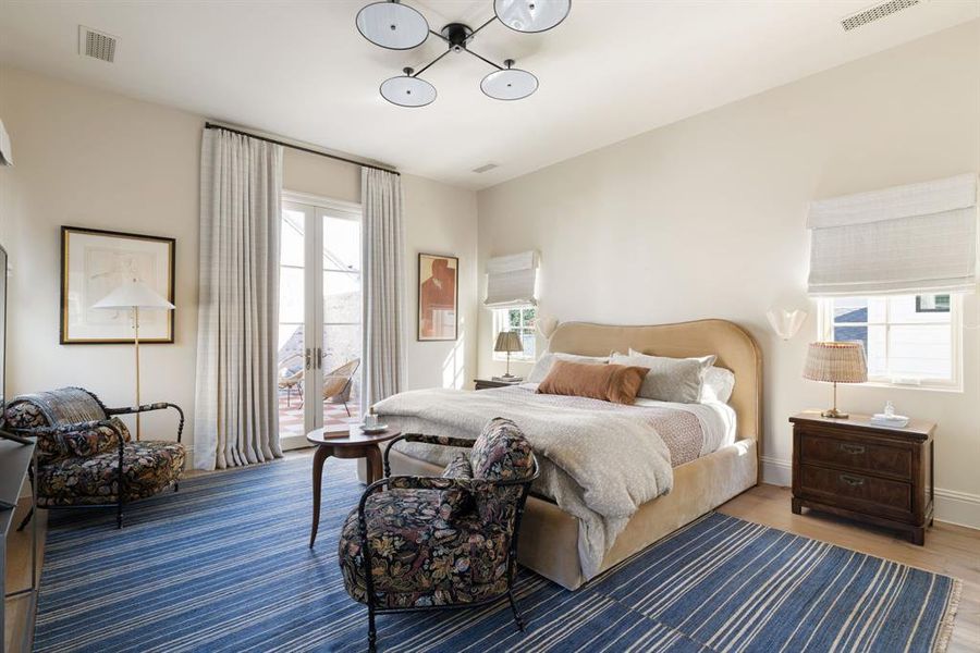 Bedroom featuring multiple windows, access to outside, wood finished floors, and french doors