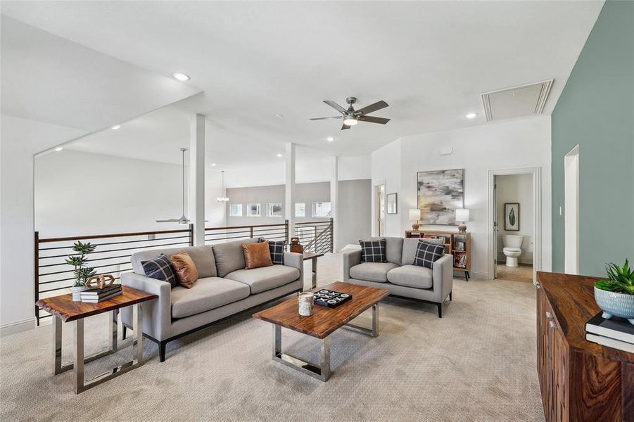 Open-concept loft area featuring carpeted flooring, a ceiling fan, recessed lighting, and a modern horizontal slat railing system