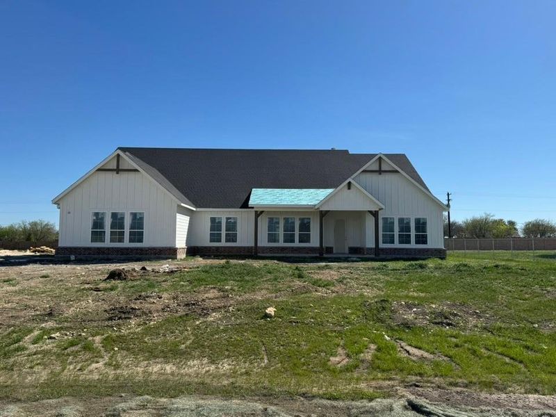 View of front of house featuring board and batten siding and covered porch