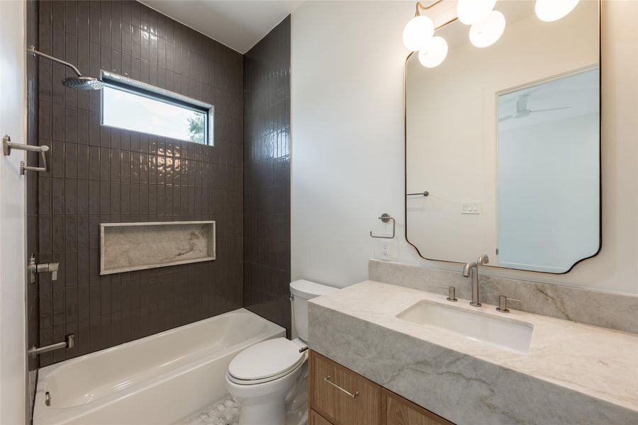 The secondary ensuite continues the home’s refined finish palette with natural stone surfaces, designer tile and a glass enclosed tub and shower, giving guests a private bath of their own. The secondary ensuite continues the home’s refined finish palette with natural stone surfaces, designer tile and a glass enclosed tub and shower, giving guests a private bath of their own.