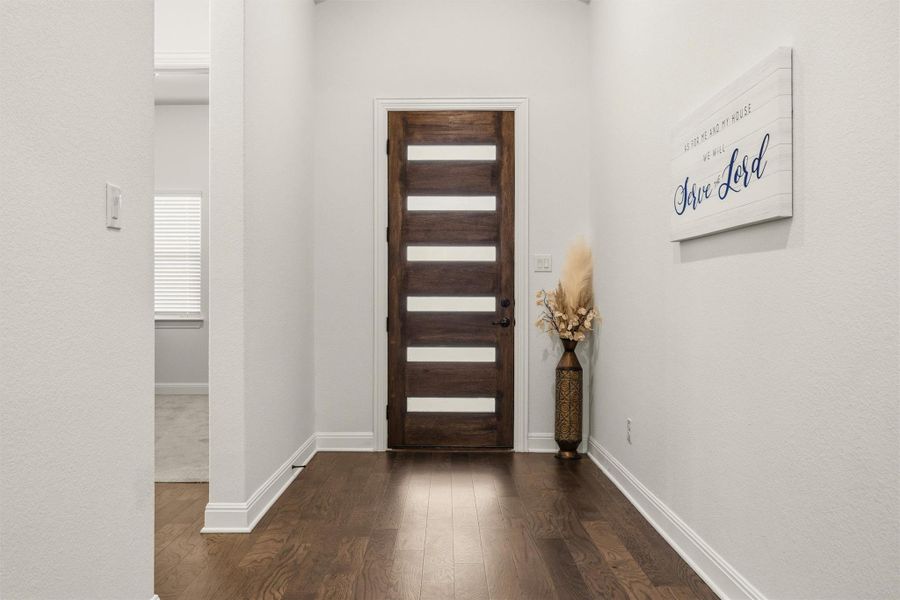Foyer entrance with dark wood finished floors and baseboards