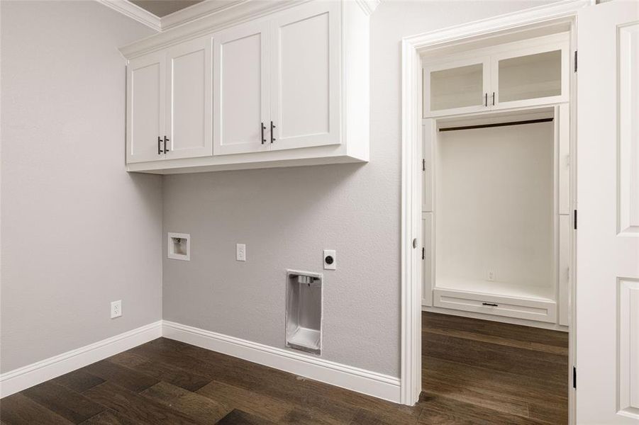 Washroom with cabinet space, hookup for an electric dryer, hookup for a washing machine, dark wood-style flooring, and baseboards Washroom with cabinet space, hookup for an electric dryer, hookup for a washing machine, dark wood-style flooring, and baseboards