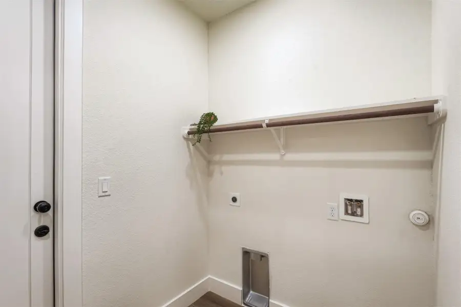 Convenient laundry space with built-in hanging rack and additional storage potential