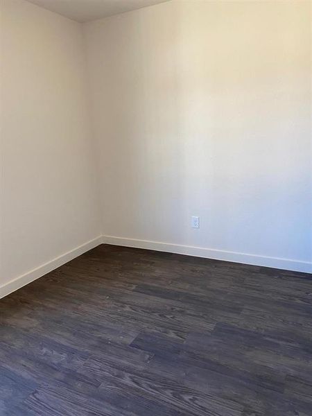 Empty room with baseboards and dark wood finished floors