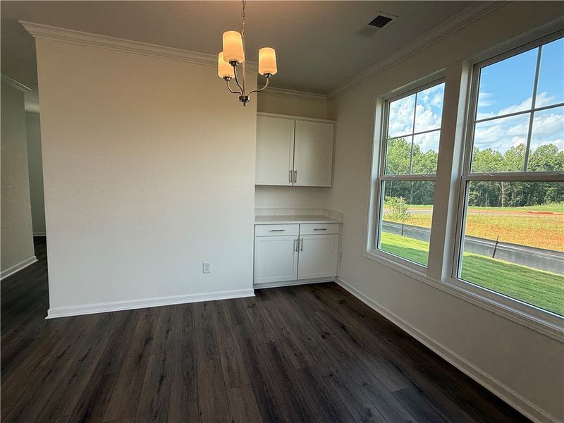 A well-lit dining area features rich wood flooring A well-lit dining area features rich wood flooring