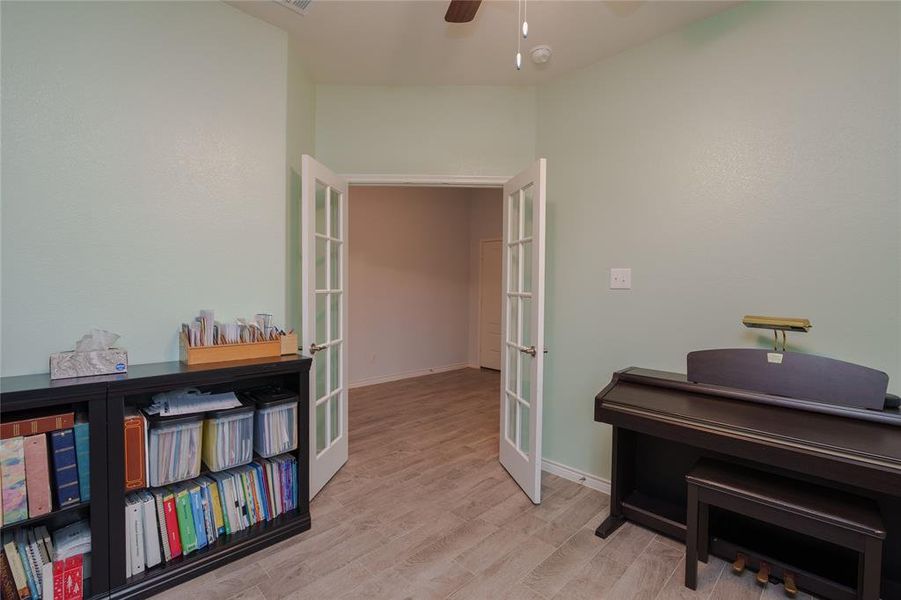 Miscellaneous room with french doors, light hardwood / wood-style flooring, and ceiling fan