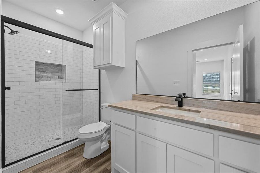 Bathroom with toilet, hardwood / wood-style floors, vanity, and walk in shower