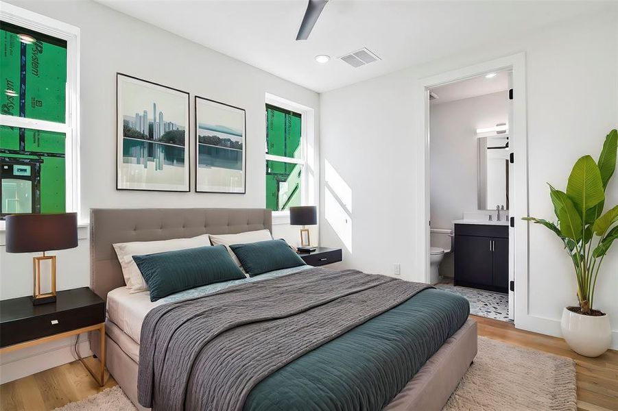 Bedroom featuring connected bathroom, light hardwood floors, ceiling fan, and sink