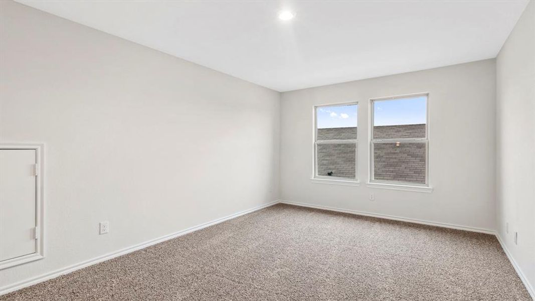 Room featuring two windows, neutral wall tones, and textured carpeting