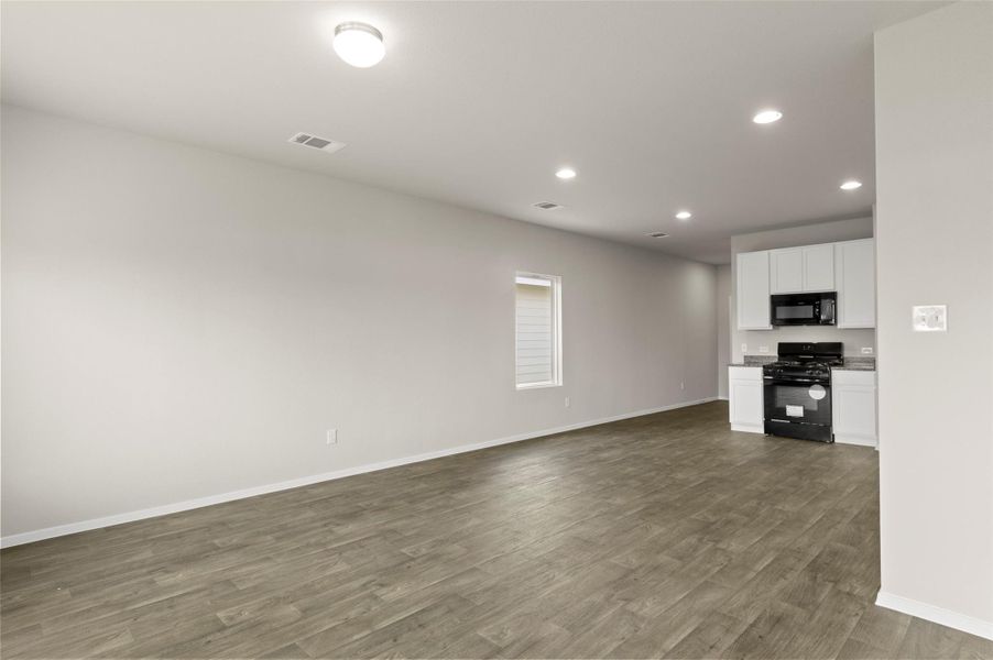 Unfurnished living room with recessed lighting and dark wood-type flooring