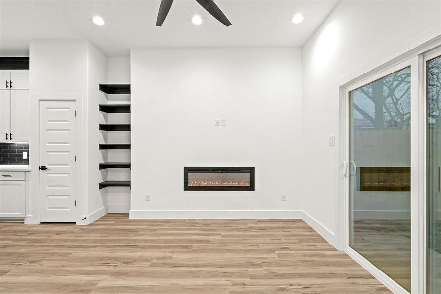 Unfurnished living room with ceiling fan and light wood-type flooring