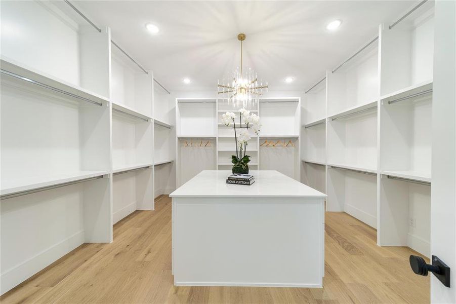 Walk in closet featuring a chandelier and light wood-type flooring