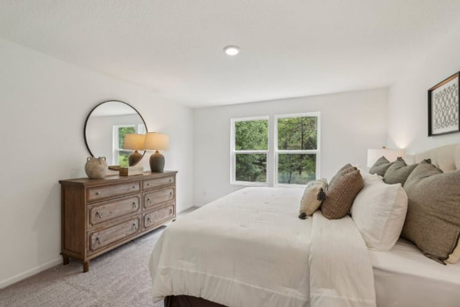 A bedroom with a bed and a dresser.