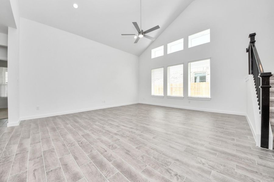 Welcome family and guests to your charming living room! With its high ceilings, recessed lighting, ceiling fan, custom paint, beautiful flooring, and large windows that let in abundant natural light, this room is perfect for gatherings. Sample photo of completed home with similar floor plan. Actual colors and selections may vary. Welcome family and guests to your charming living room! With its high ceilings, recessed lighting, ceiling fan, custom paint, beautiful flooring, and large windows that let in abundant natural light, this room is perfect for gatherings. Sample photo of completed home with similar floor plan. Actual colors and selections may vary.