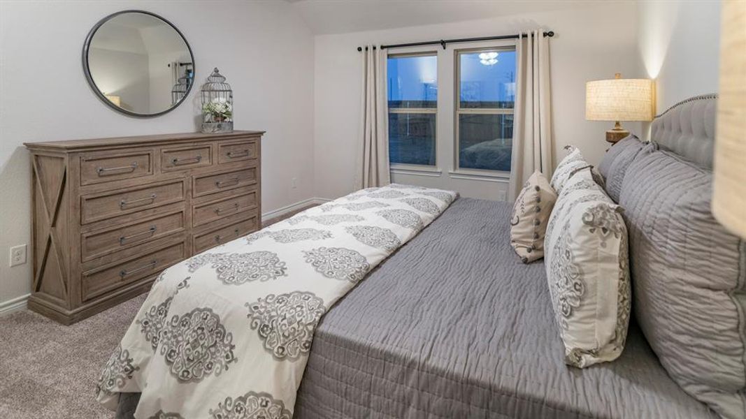 Bedroom featuring light carpet and baseboards Bedroom featuring light carpet and baseboards