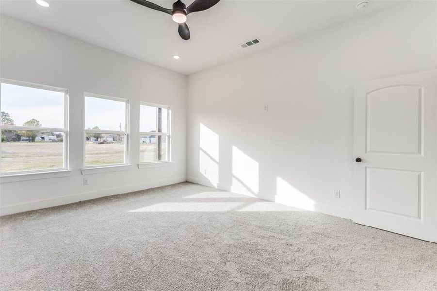 Carpeted empty room with ceiling fan