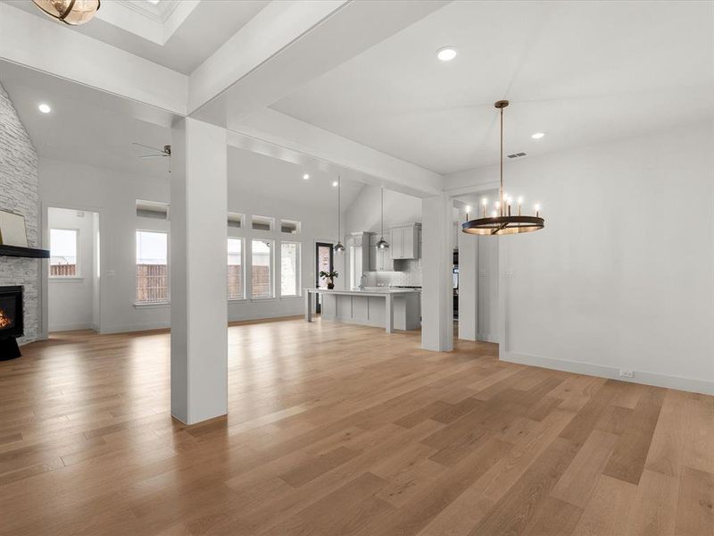 Unfurnished living room with a chandelier, light wood-style flooring, a fireplace, and recessed lighting Unfurnished living room with a chandelier, light wood-style flooring, a fireplace, and recessed lighting