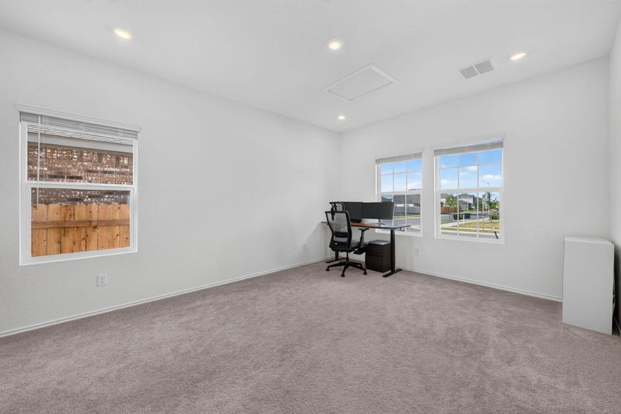 A well-lit versatile space features multiple windows and soft carpeting, ideal for an office or bonus room. A well-lit versatile space features multiple windows and soft carpeting, ideal for an office or bonus room.