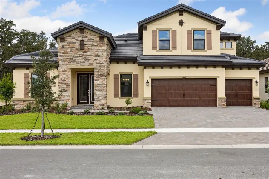 Front exterior of a new home in Triple Creek, Riverview, FL, highlighting curb appeal (Image 2).