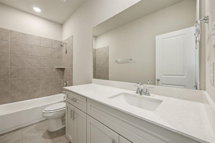 Full bath with vanity, shower / bath tub combination, tile, and toilet