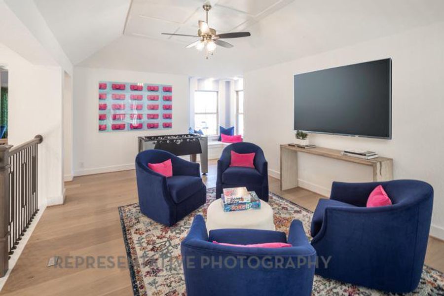 Living area featuring lofted ceiling, baseboards, a ceiling fan, and wood finished floors Living area featuring lofted ceiling, baseboards, a ceiling fan, and wood finished floors