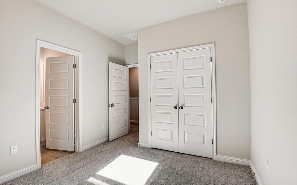 Unfurnished bedroom with light colored carpet and a closet