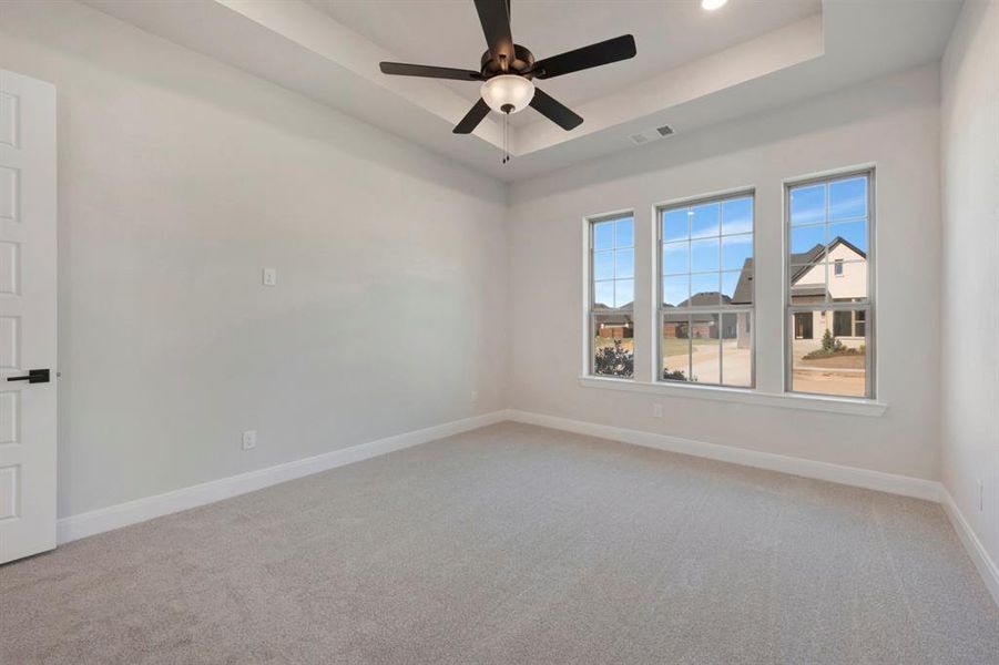 Unfurnished room featuring light carpet, a ceiling fan, a raised ceiling, and recessed lighting