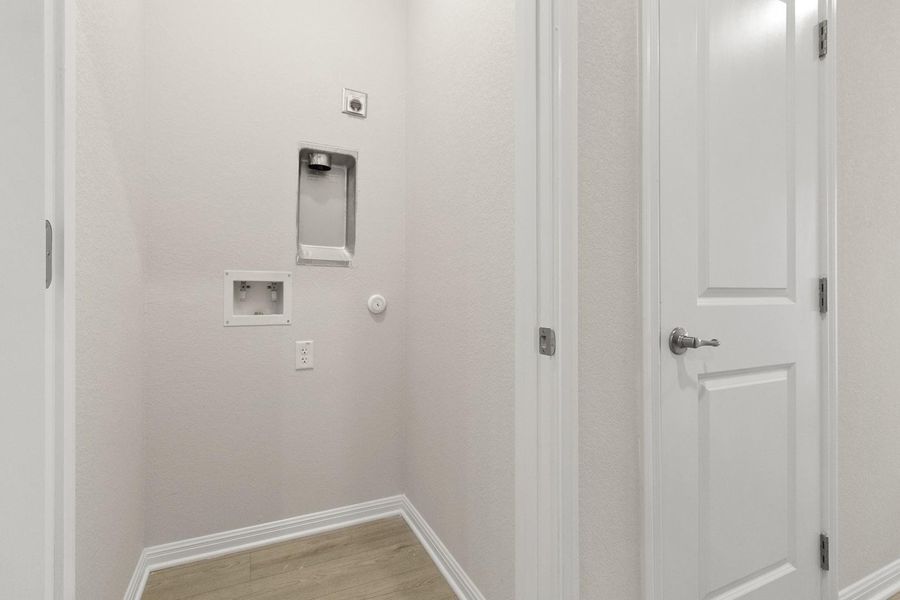 The property features a dedicated laundry area with light-colored walls and a light wood-look floor