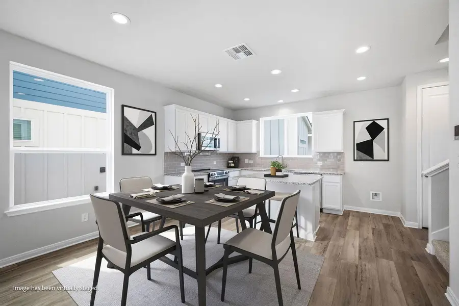 Gleaming hardwood floors and recessed lighting enhance this modern open concept kitchen and dining space. Gleaming hardwood floors and recessed lighting enhance this modern open concept kitchen and dining space.