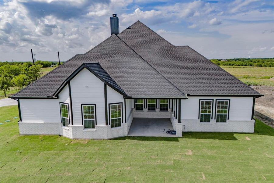 Rear view of house with a yard and a patio area