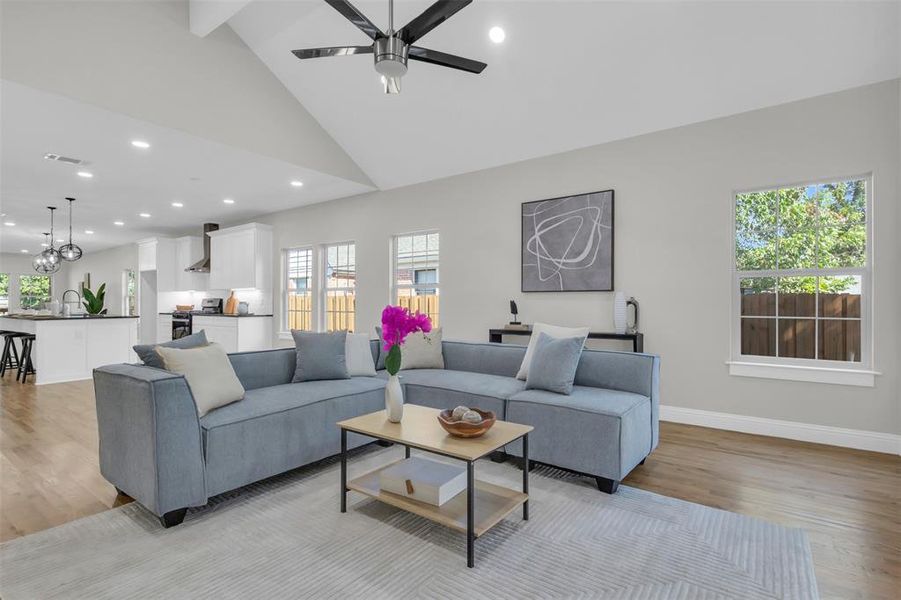 Living area with recessed lighting, high vaulted ceiling, light wood-type flooring, a chandelier, and a ceiling fan