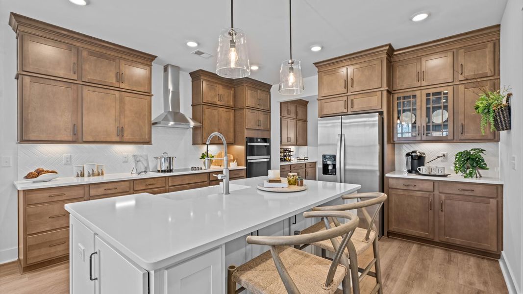Superior kitchen with quartz countertops, pendant lighting, and a generously sized island