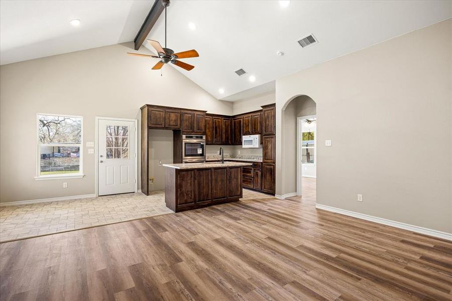 Kitchen featuring a ceiling fan, open floor plan, dark wood finish cabinetry, and arched walkways  4403 N. Port Ridglea Ct. Granbury,TX 76049