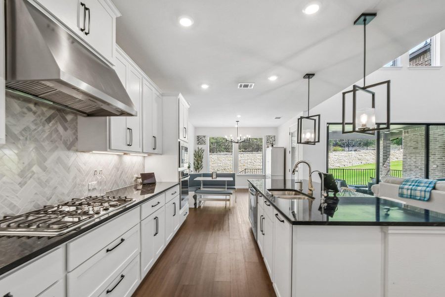 Streamlined kitchen layout offers ample counter space, rich hardwood flooring, and a luminous dining nook.