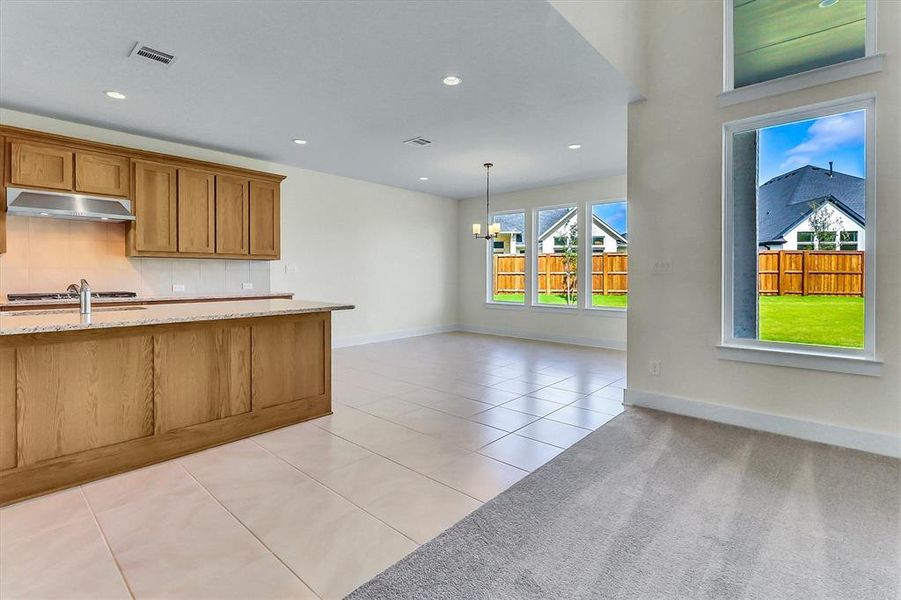 Contemporary kitchen island with a light-toned countertop and sink, complemented by recessed lighting and a stainless steel range hood Contemporary kitchen island with a light-toned countertop and sink, complemented by recessed lighting and a stainless steel range hood