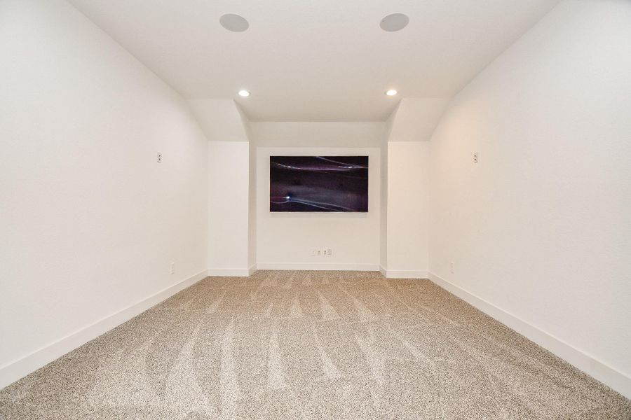 The room showcases a cozy, carpeted media room with recessed lighting, perfect for an intimate entertainment space. The room showcases a cozy, carpeted media room with recessed lighting, perfect for an intimate entertainment space.