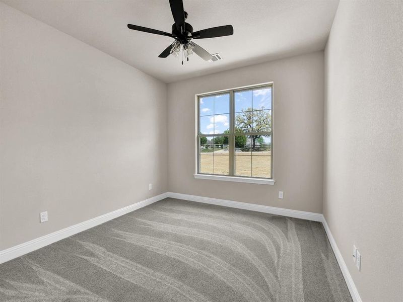 Carpeted spare room featuring baseboards, visible vents, and ceiling fan Carpeted spare room featuring baseboards, visible vents, and ceiling fan