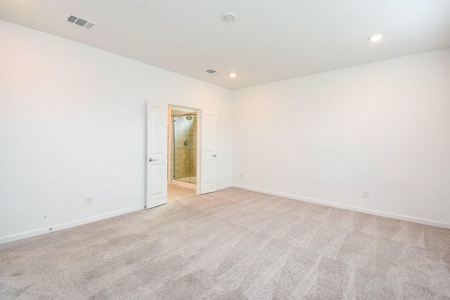 VIEW OF PRIMARY BEDROOM SHOWING THE ENTRY TO THE PRIMARY BATHROOM