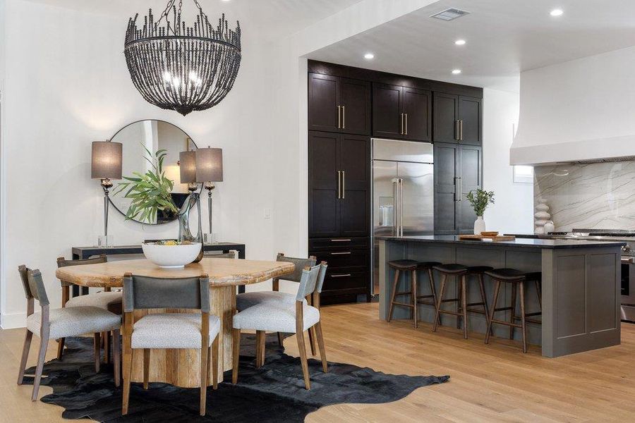 An inviting open-concept space features a well-appointed kitchen island, a dining area, and warm hardwood flooring throughout.