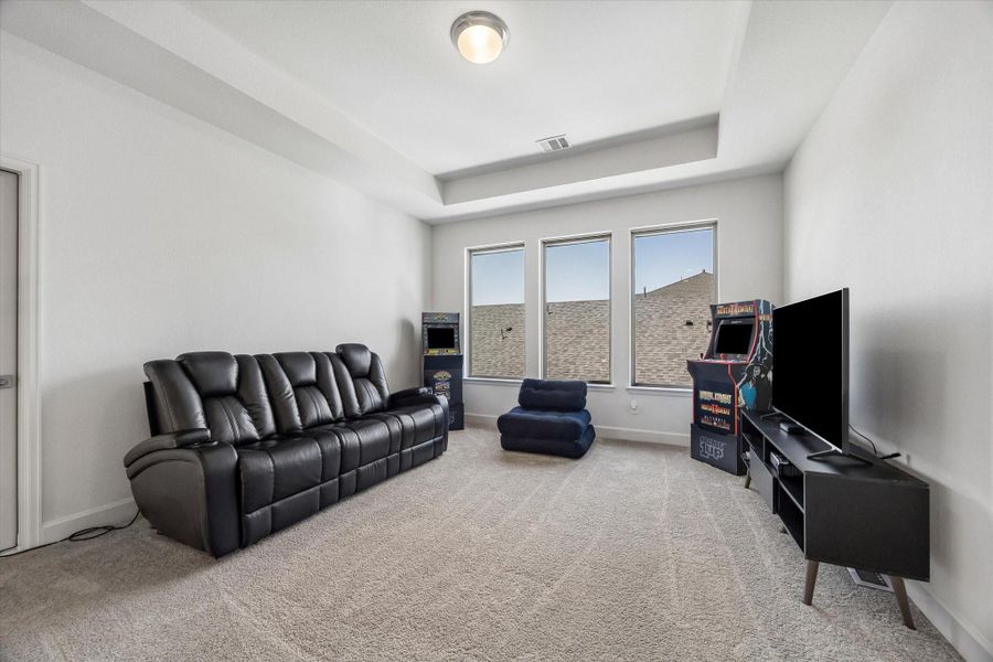 Spacious upstairs game room with tray ceiling, abundant natural light and endless possibilities for entertaining