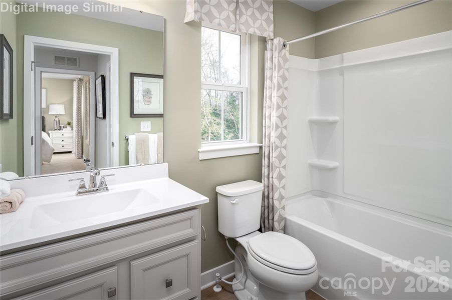 Sleek, spacious, and effortlessly stylish—this shared full bath on the upper level is a total showstopper. Natural light pours in through the window, illuminating clean lines and built-in shower shelves that blend form with function. It’s a polished retreat designed for comfort and ease.