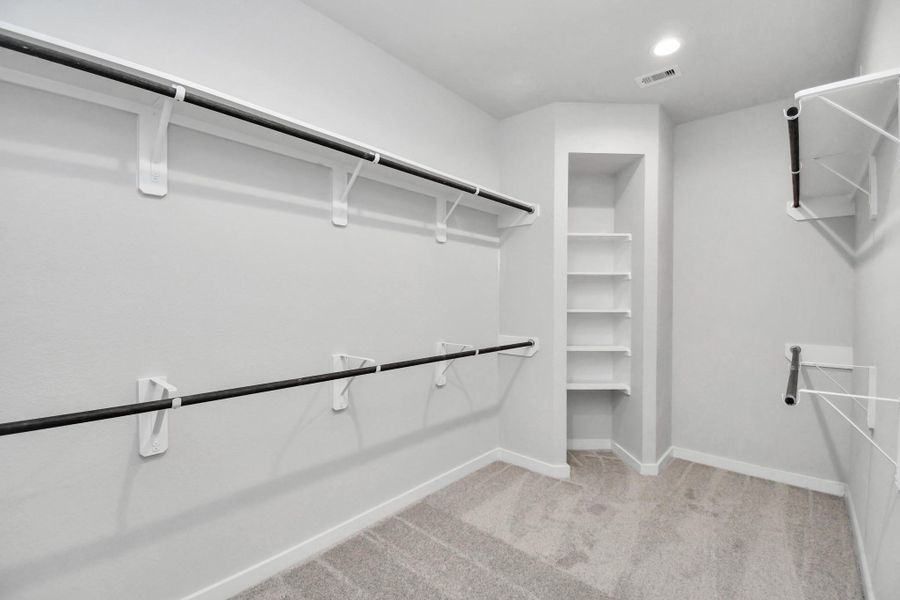 Walk-in closet that epitomizes luxury and practicality. This generously sized space features built-in shelving, offering abundant room for impeccable organization. High ceilings and recessed lighting create a bright and welcoming ambiance. Sample photo of completed home with similar floor plan. Actual colors and selections may vary. Walk-in closet that epitomizes luxury and practicality. This generously sized space features built-in shelving, offering abundant room for impeccable organization. High ceilings and recessed lighting create a bright and welcoming ambiance. Sample photo of completed home with similar floor plan. Actual colors and selections may vary.