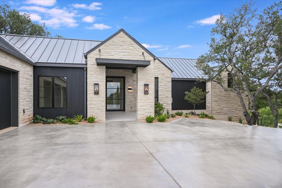 Modern stone and siding facade offers exceptional curb appeal and privacy.